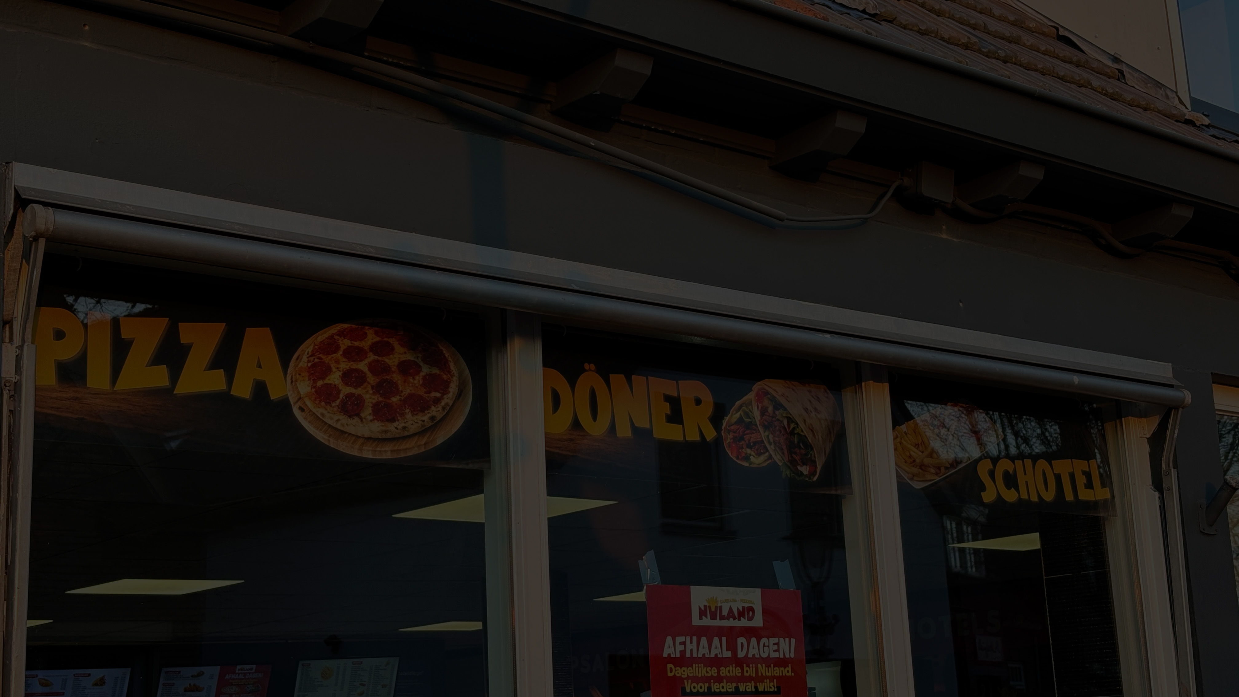 Raambelettering met pizza, döner en schotel bij Cafetaria Nuland