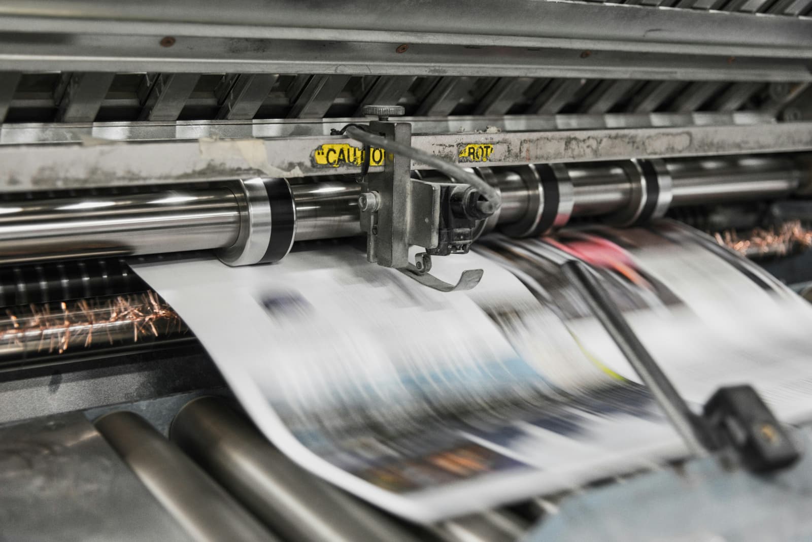 Drukpers waar vers bedrukt papier doorheen loopt