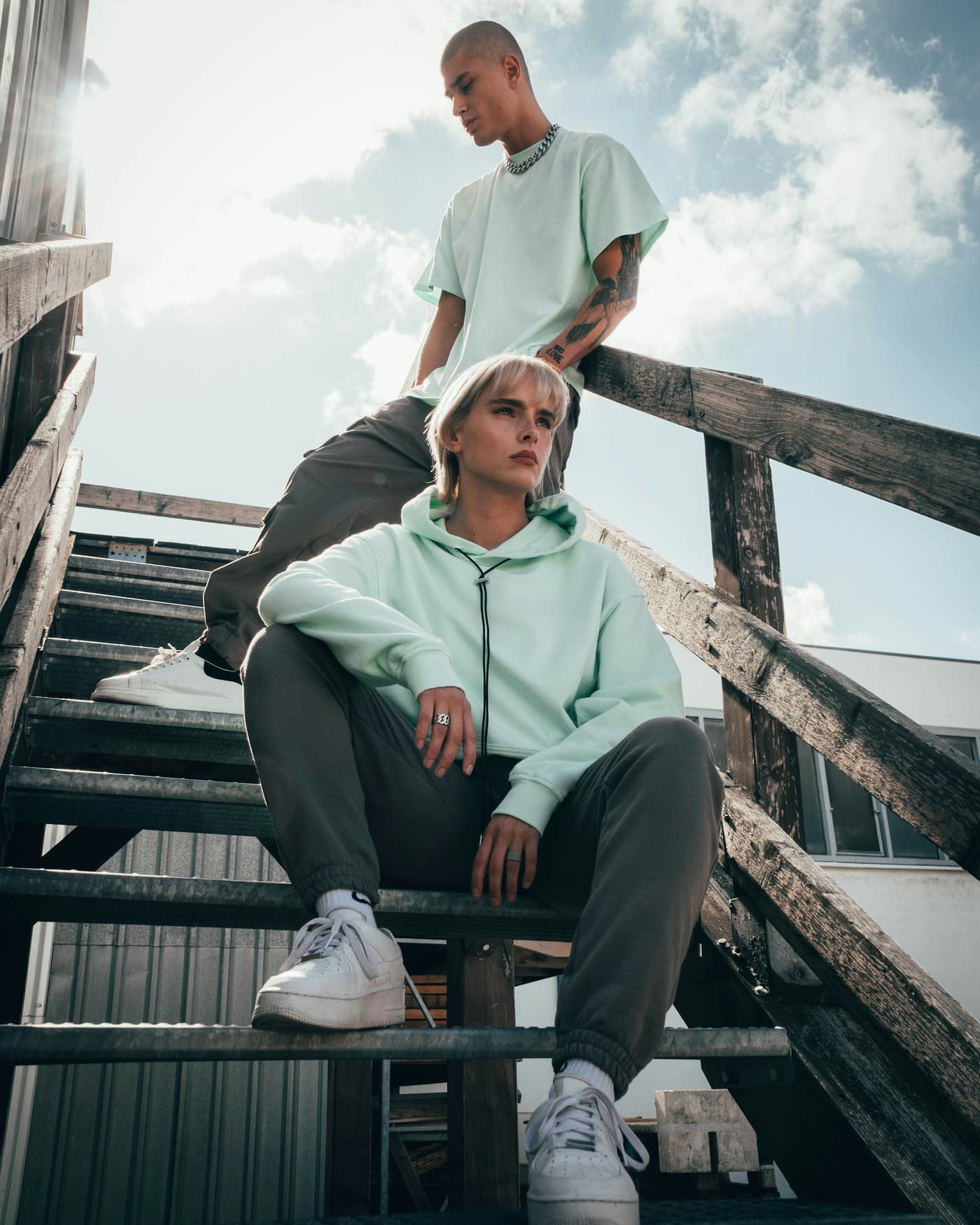 Twee modellen in mintgroene streetwear op een buitentrap